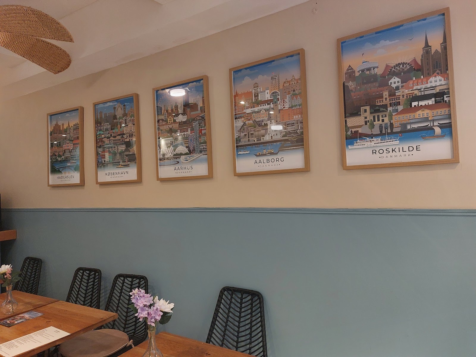 La salle du Café Danica : mur bleu fjord et affiches des villes danoises