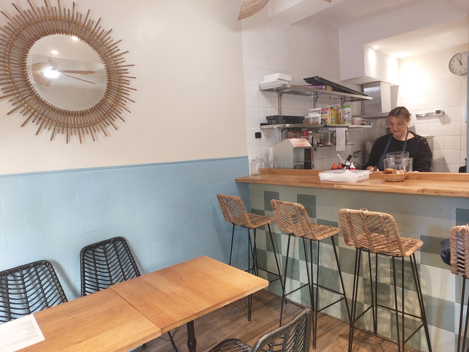 Comptoir du Café Danica avec tabourets en rotin et cuisine ouverte